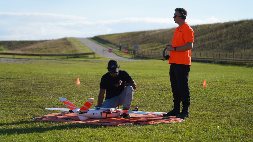 Two drone pilots in a field setting up the Sentaero 5 for a BVLOS mission